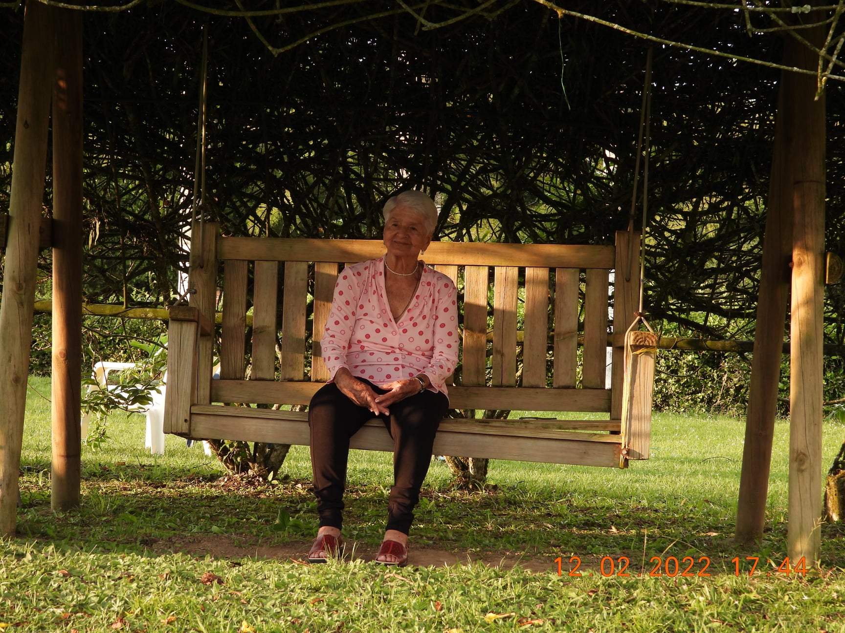 Elenita en la banca del jardín de la finca